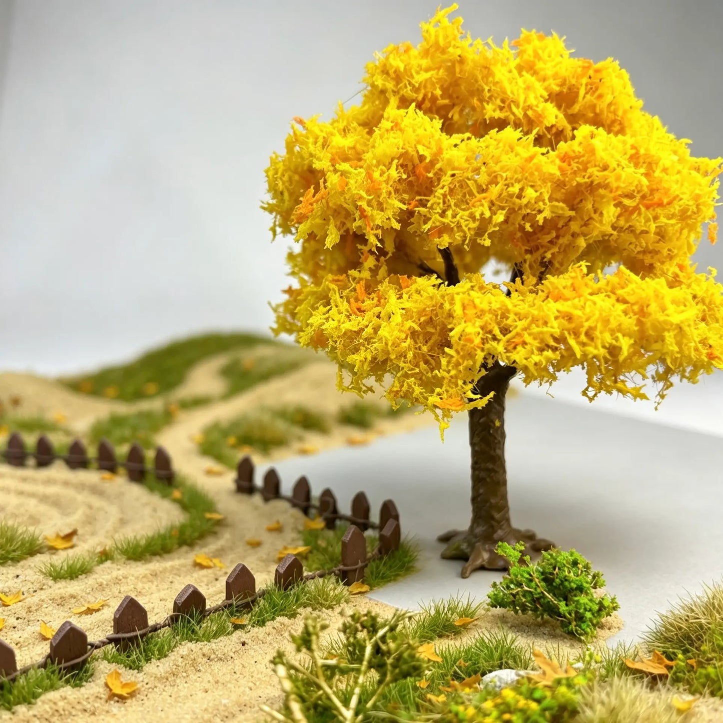 Macro close-up of fluffy yellow-orange autumn leaves on scale model tree, layered dense canopy for wargame terrain decoration