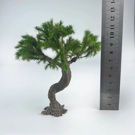 Close-up hand holding curved textured bark trunk of mini bonsai pine model, realistic rough wood grain for oriental scene detail making