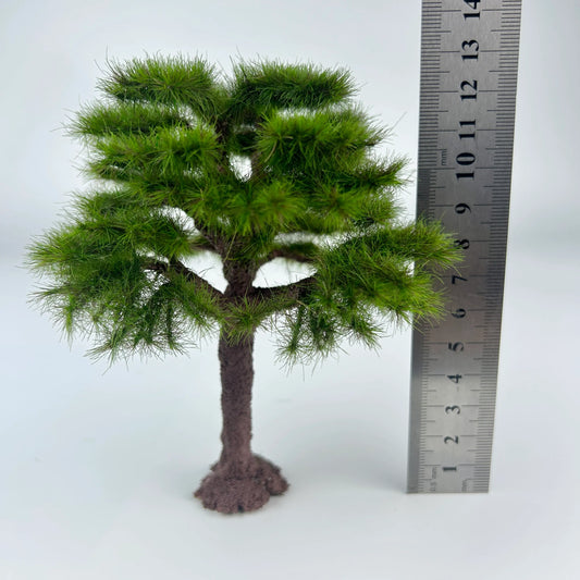Miniature pine tree placed on sand terrain diorama layout, realistic outdoor landscape effect for railroad and wargame scenery
