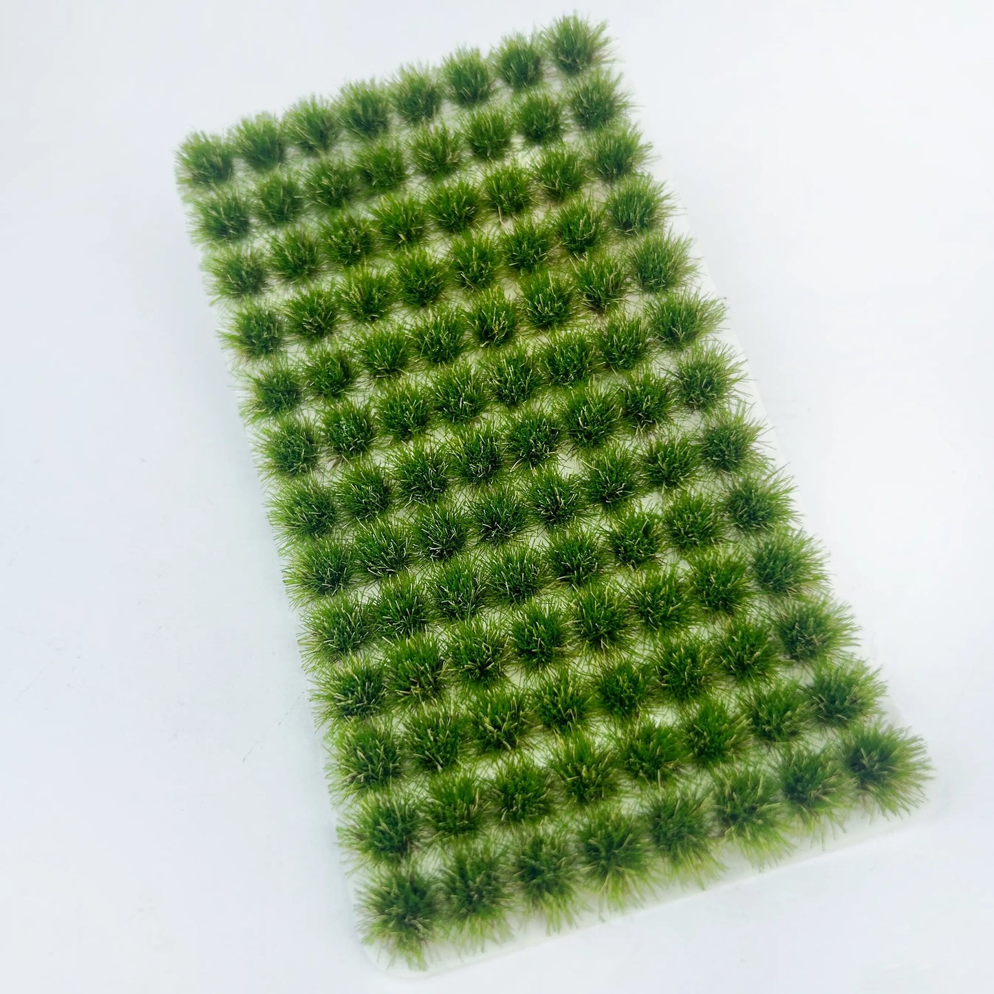 Pack of 104 self-adhesive static grass tufts sheet, 10.8cmx6cm overall size with deep vibrant green mini foliage clumps, close-up detail display, static grass tufts, miniature diorama supplies, wargame terrain material, model railway grass, self-adhesive grass clusters, scale model scenery, warhammer terrain, hobby craft grass