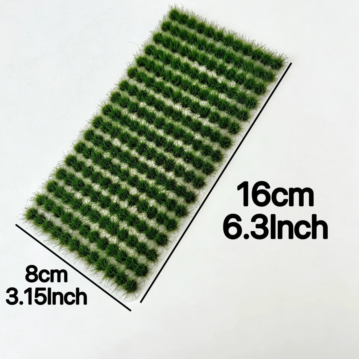 Realistic grass tufts beside a model railway track, stone wall and country path