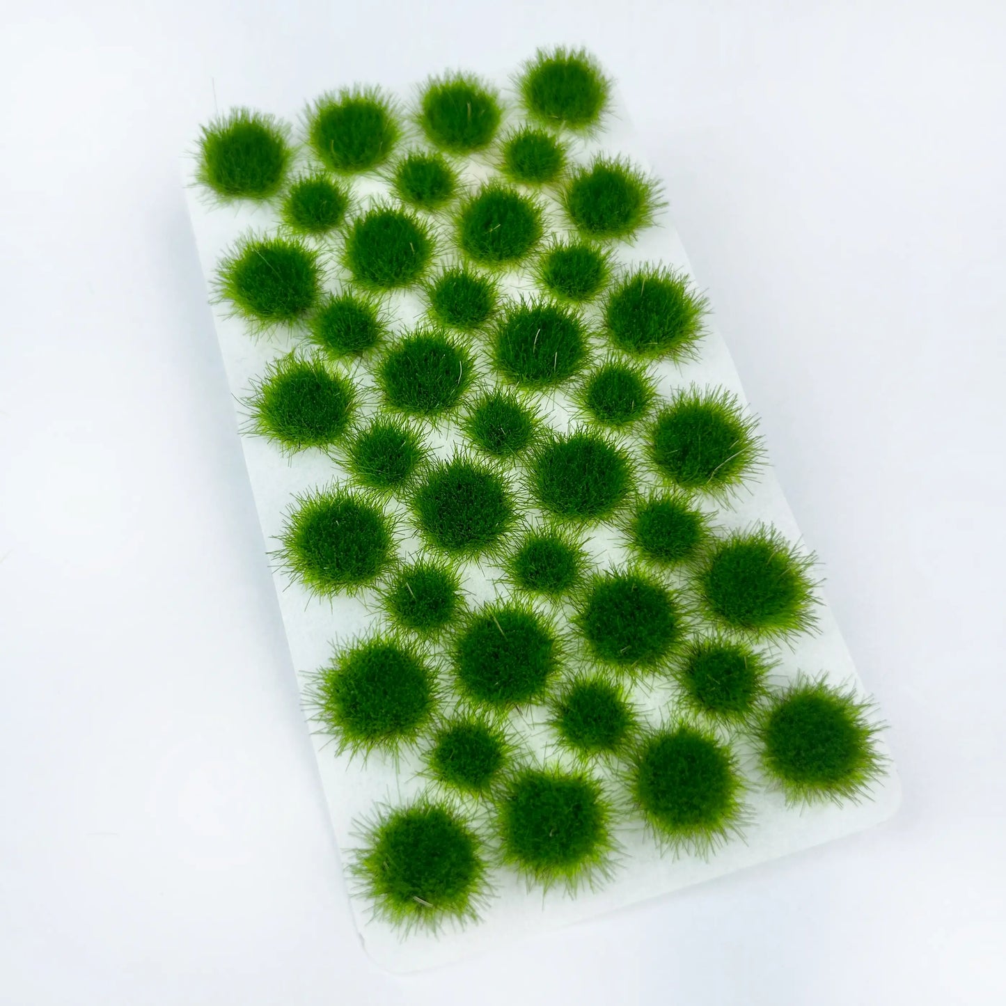 Self-adhesive summer vibrant solid deep green static tuft grass sheet with dense round grass clumps, high-detail miniature terrain material for forest, garden and realistic tabletop wargame landscape