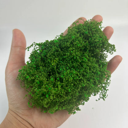 Mixed green artificial moss with tiny pink flowers, realistic miniature plant for dollhouse garden decor, scale model terrain, and diorama scenery.