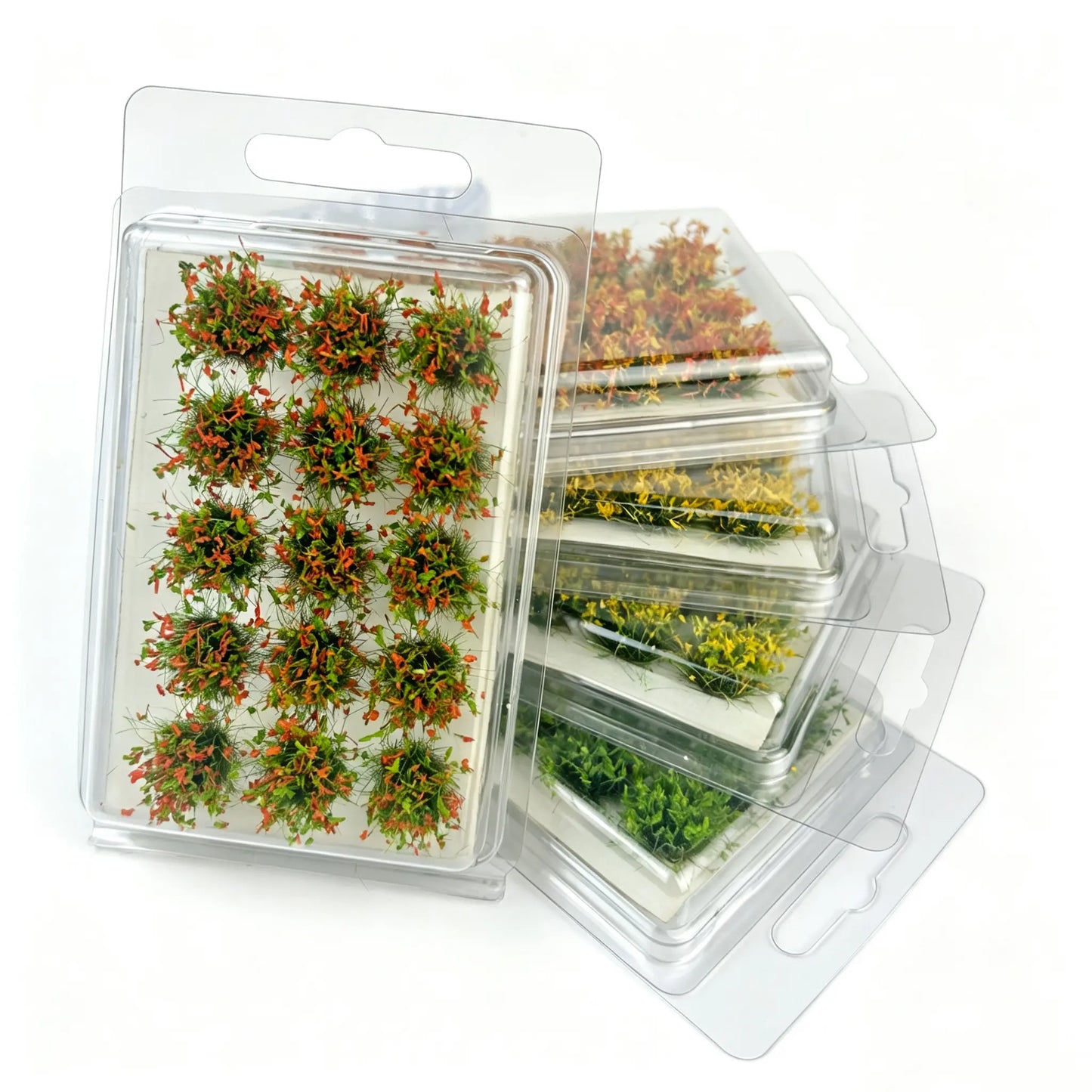 Multi seasonal tone static grass tuft sets stacked in transparent hanging storage boxes, assorted miniature grass clump packs for full diorama terrain, wargame base and scale model scenery crafting