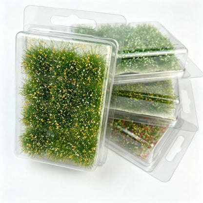 Miniature grass tufts with forest diorama, moss and rock scenery for realistic scale model landscape.
