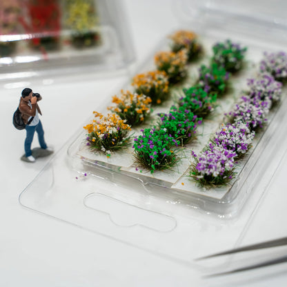 Close-up shot of single red mini flower cluster picked by tweezers, self-adhesive base for diorama terrain building
