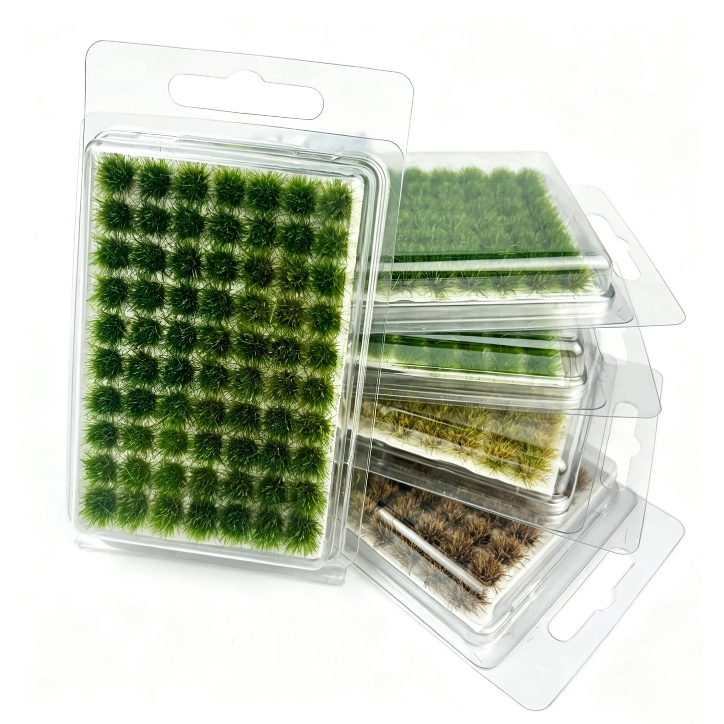 Stacked hanging blister packs of self-adhesive static grass tufts in 4 seasonal natural shades, complete multi-color set display for miniature diorama, wargame terrain, model railway and military scenery crafting supplies
