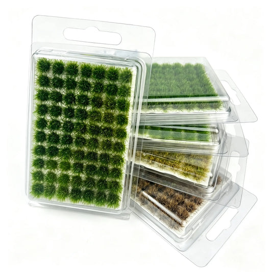 Stacked hanging blister packs of self-adhesive static grass tufts in 4 seasonal natural shades, complete multi-color set display for miniature diorama, wargame terrain, model railway and military scenery crafting supplies