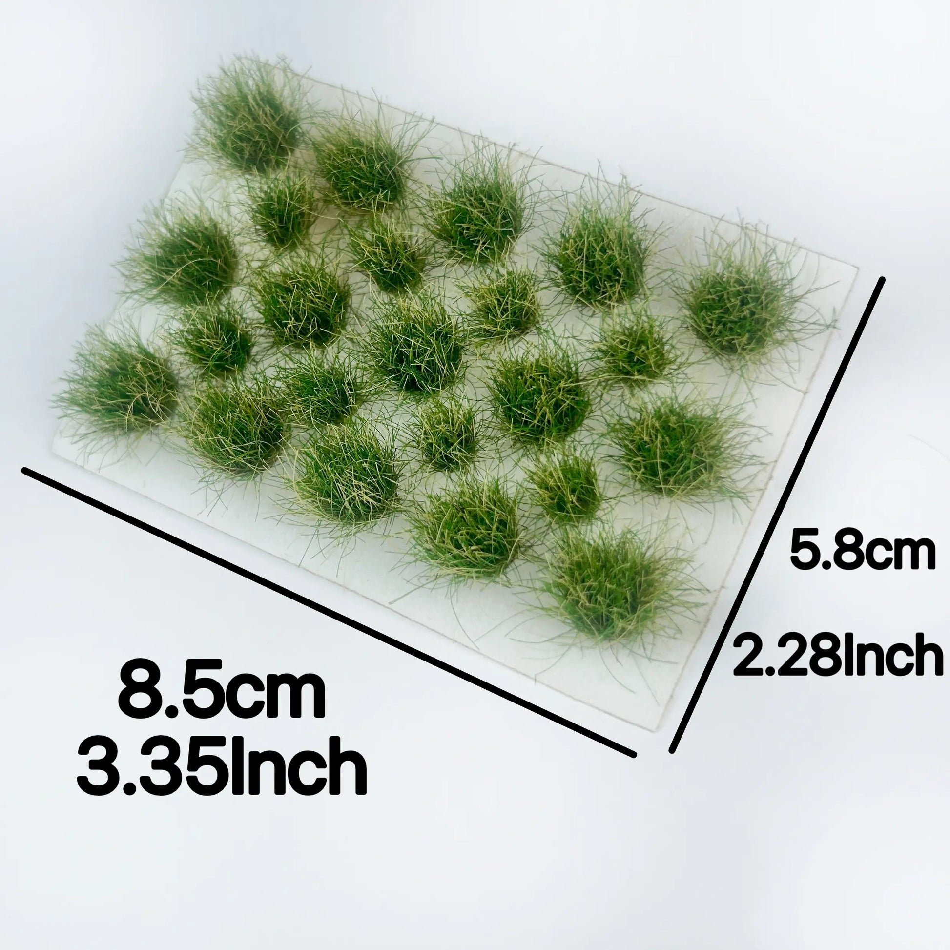 Self-adhesive grass tuft sheet with size dimension labels 8.5cm x 5.8cm, spring green miniature wild grass clusters, scale reference product shot for diorama hobby terrain material
