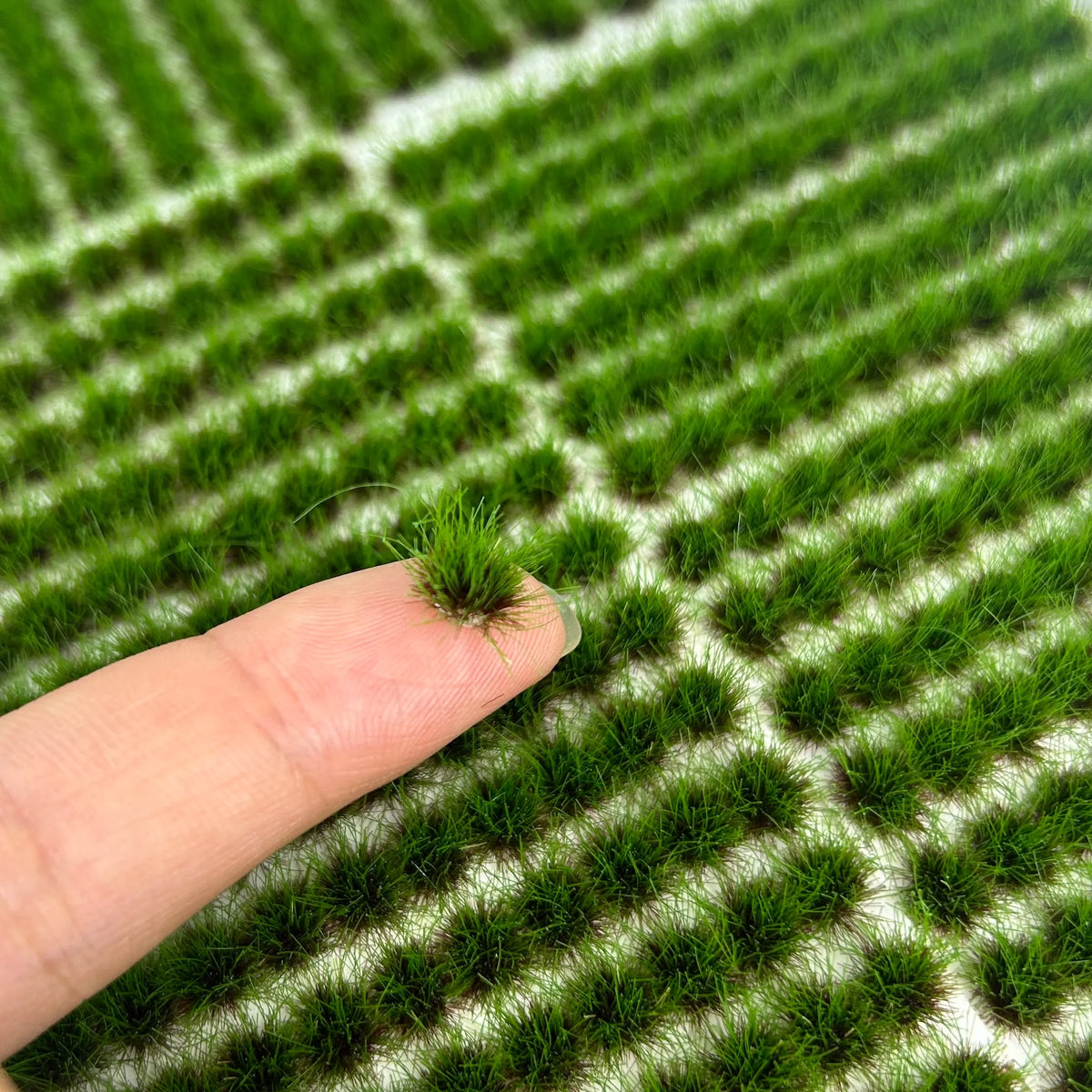 Close-up of dense green static grass tufts for miniature landscapes and dioramas