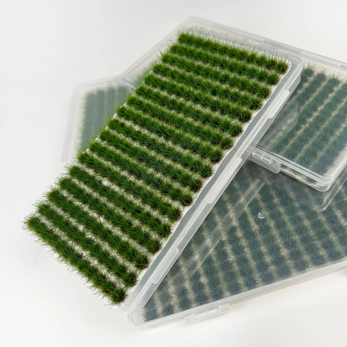 Individual green grass tuft lifted from the sheet for easy placement on miniature scenery