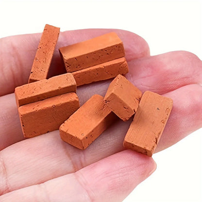 Hand‑held shot of realistic tiny simulation red bricks for scale‑model terrain making 