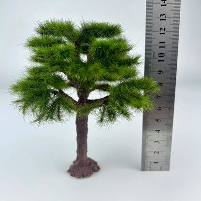 Miniature pine tree placed on sand terrain diorama layout, realistic outdoor landscape effect for railroad and wargame scenery