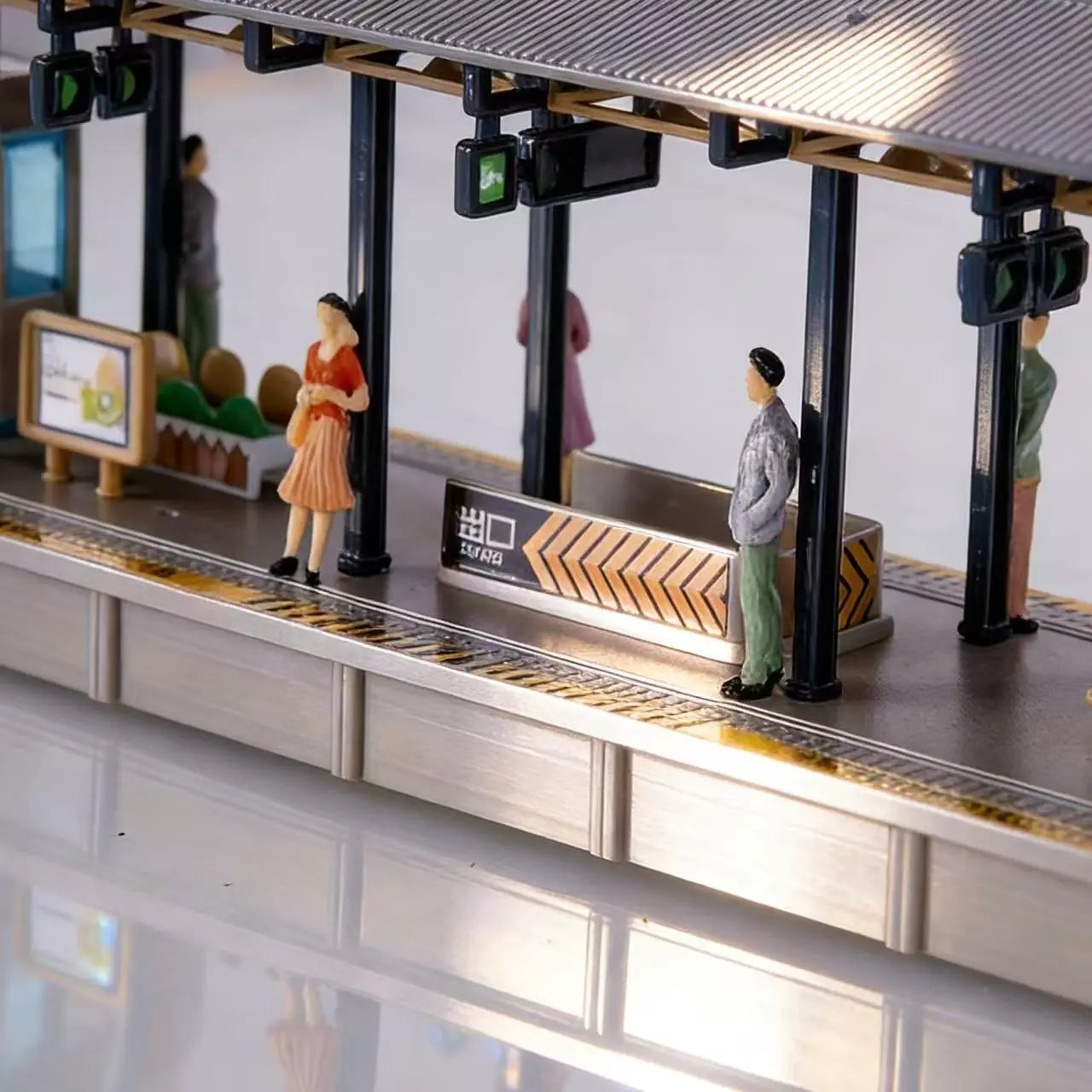 Finished scale model railway station platform diorama layout decorated with colorful miniature people figures, realistic waiting crowd tiny human miniatures for train railway scenery, urban city wargame terrain handmade craft
