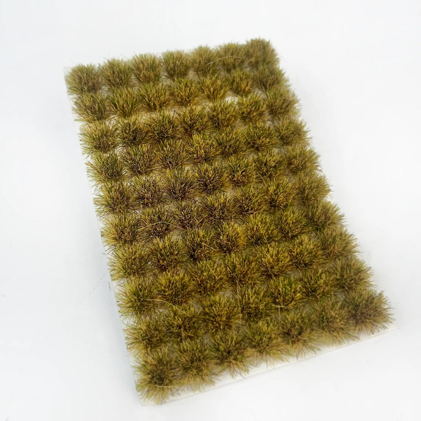 Self-adhesive mixed tan and light green miniature grass tuft mat with full size measurements marked, for autumn wilderness, rural diorama and wargame terrain craft reference