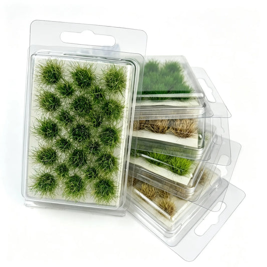 Multi-color pre-made self-adhesive grass tuft sheet laid out as rural farm field, fresh green, yellow and brown dry grass clusters, farmer miniature figure, golden sunset countryside background, miniature terrain foliage material for DIY diorama and wargame scenery making