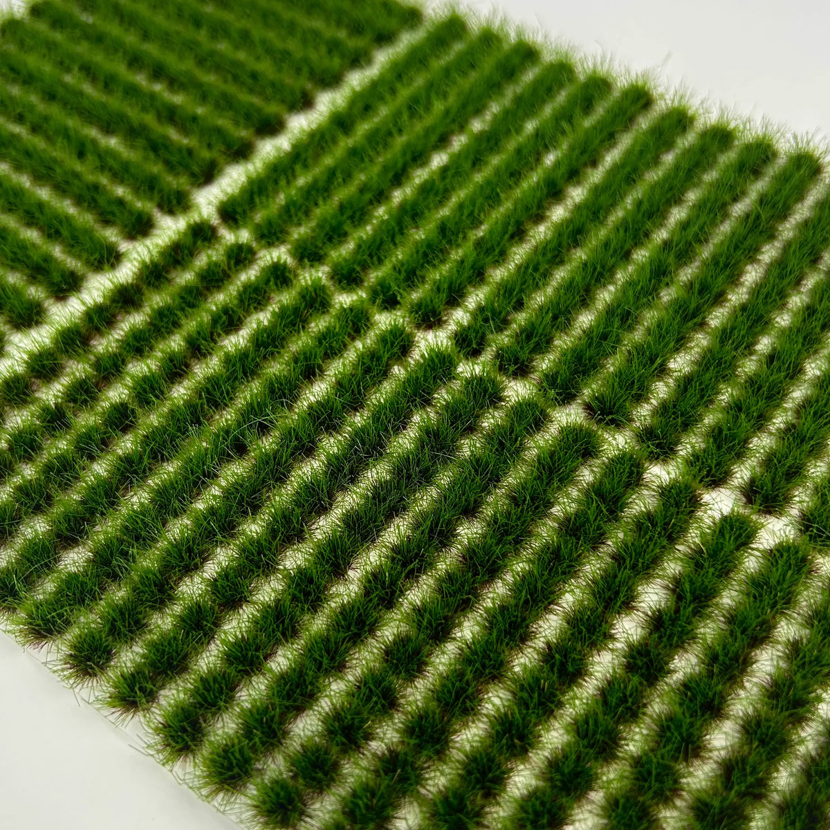 Trays of 204 green grass tufts packed in clear reusable storage boxes