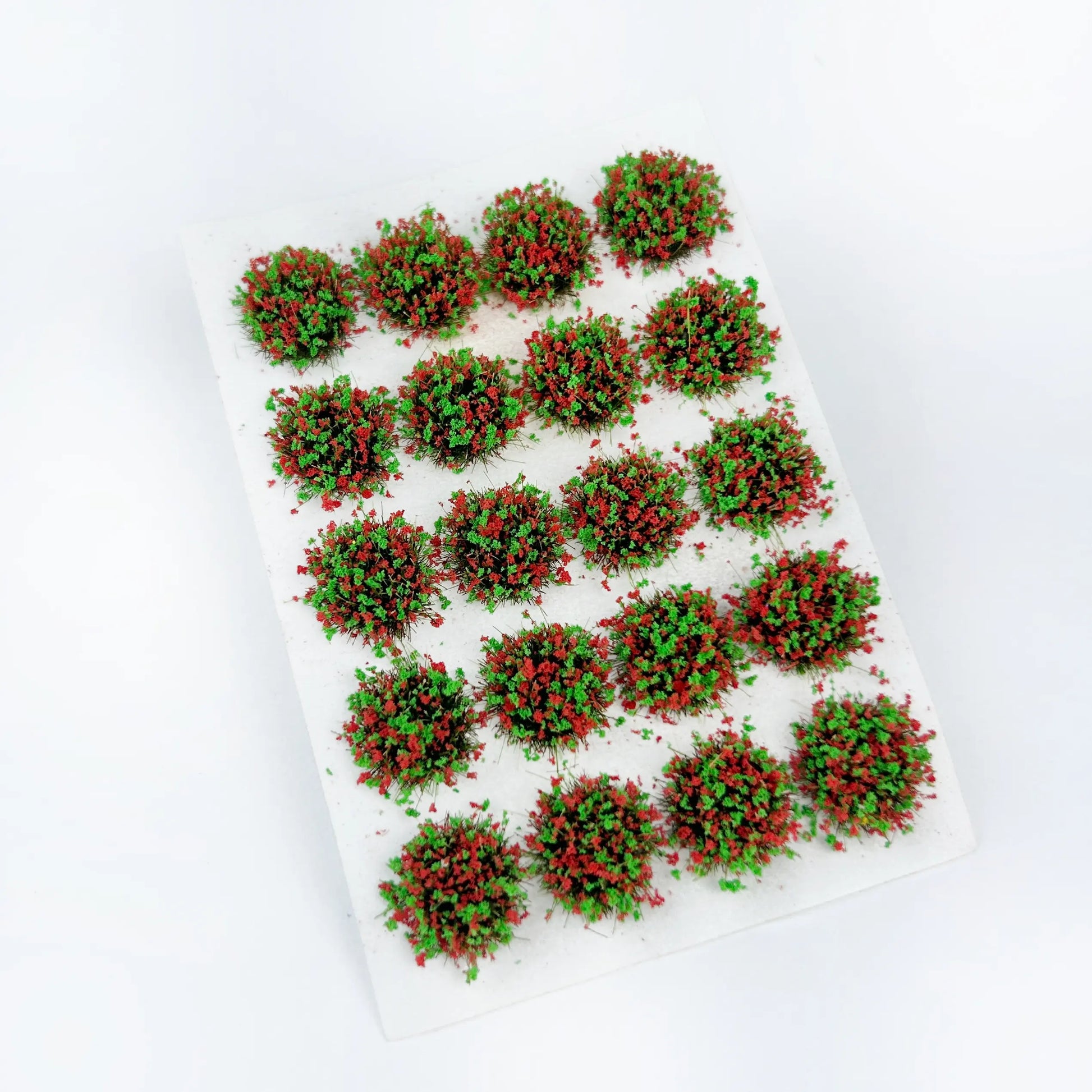 Green base round static grass tuft sticker sheet scattered with bright red berry & flower clusters, vivid mixed tone mini grass clumps for autumn or orchard themed diorama, wargame terrain and scale model landscape craft
