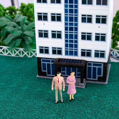 City residential building scale model diorama scene with couple tiny human figures standing on static grass mat, urban street miniature terrain decoration for railway layout and wargame craft supplies