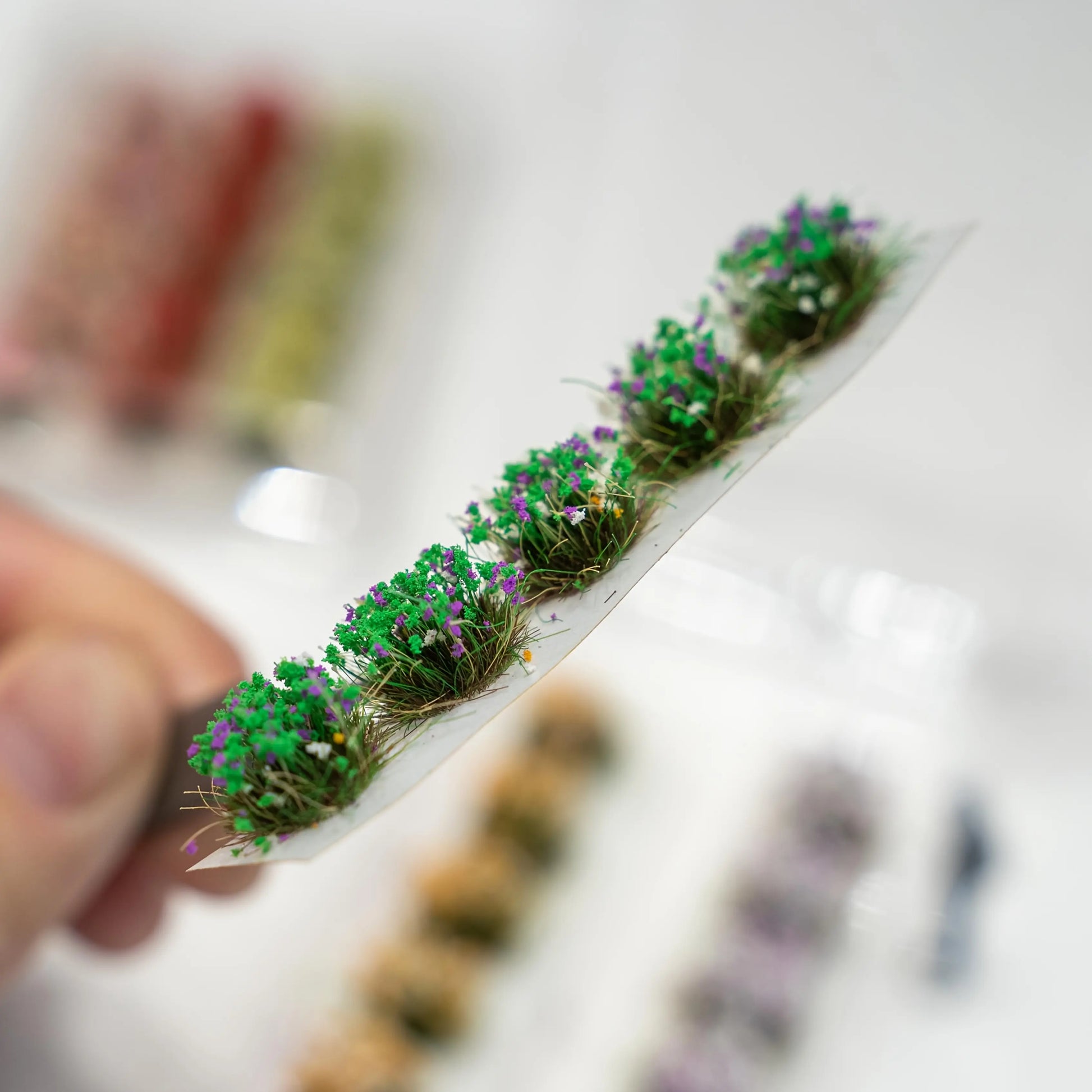 Green purple flower tuft strip with dense grass texture, miniature roadside scenery accessory for train layout diorama
