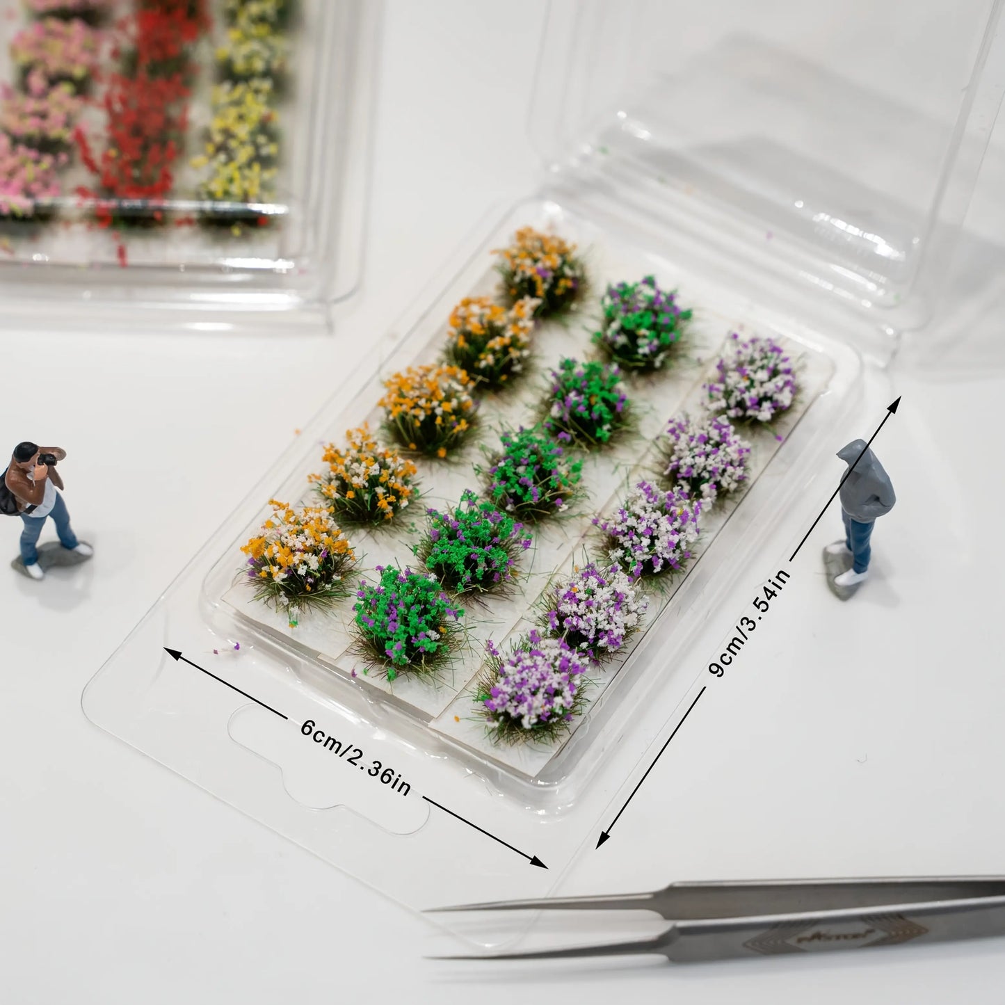 Orange green purple mixed miniature flower tuft set, scale model railway scenery material with human figure proportion reference
