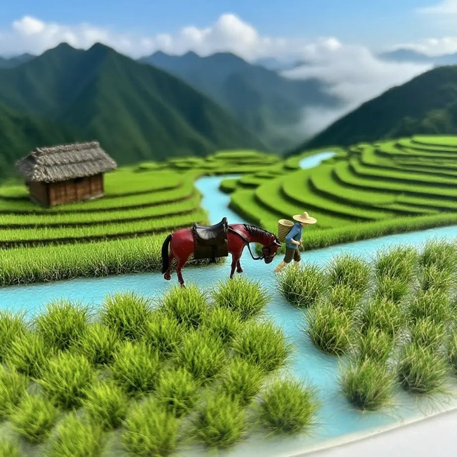 Lush spring mountain rice terrace miniature diorama layout, vibrant green self-adhesive grass tufts as rice crops, winding river, thatched cottage, farmer and horse miniatures, mountain valley landscape model for scale model hobby and tabletop scenery building
