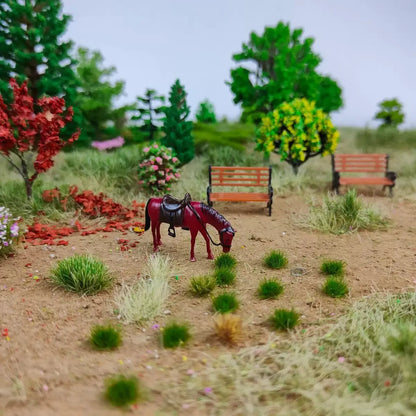 Hobby tutorial shot showing placing self-adhesive static grass tufts with tweezers on miniature park diorama base, operation demo for scale model terrain making, static grass tufts, miniature diorama supplies, wargame terrain material, model railway grass, self-adhesive grass clusters, scale model scenery, warhammer terrain, hobby craft grass
