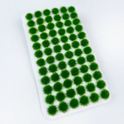 Top-down flat lay shot of lush emerald bright green self-adhesive static grass tuft sheet on pure white background, full uniform round grass clusters for miniature garden and farm terrain