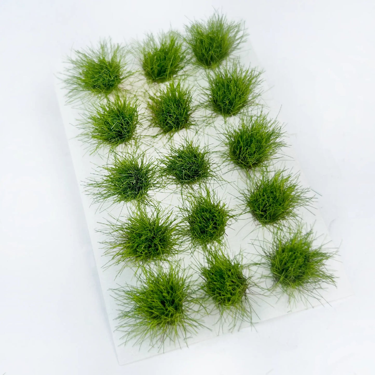Pale green miniature turf clusters, diorama meadow scenery accessory, evenly arranged round grass tufts, flat commercial shot