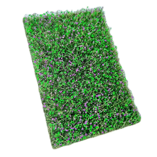 Artificial green miniature grass mat covered with tiny purple flowers, full top view for DIY diorama and micro landscape scene layout